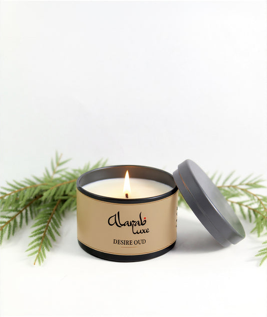 Candle in a tin with 'Alarab luxe' branding on a white background with greenery.