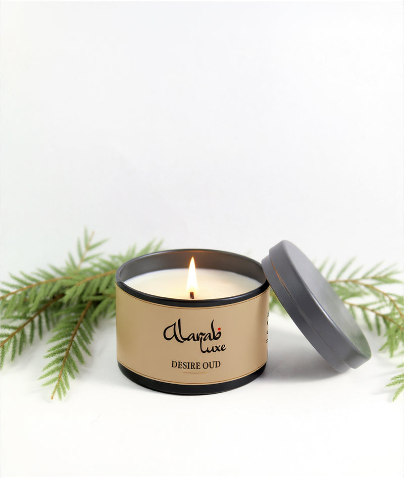 Candle in a tin with 'Alarab luxe' branding on a white background with greenery.